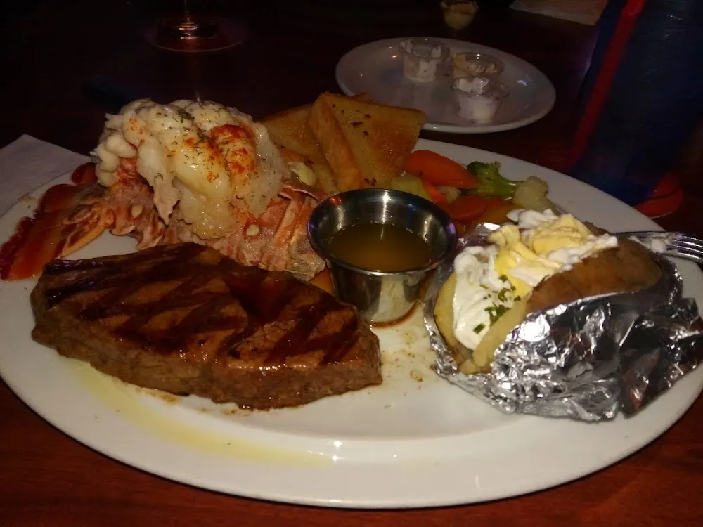 Lobster Tail Rib Eye Steak Baked Potato Garlic Bread and Veggies